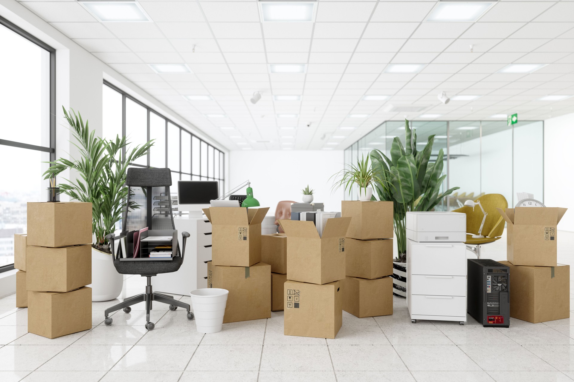 Umzug in ein neues Büro mit Stühlen, Kartons, Pflanzen, Computern und anderen Bürogeräten.